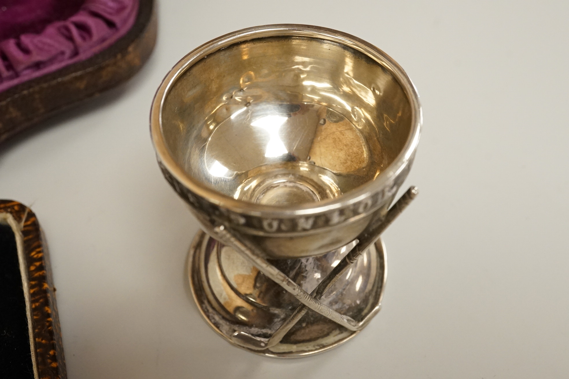 A cased pair of Victorian silver circular salts, by Edward Hutton, London, 1886, lacking spoons, together with a cased set of six silver bean end coffee spoons, a cased silver spoon, a small silver 'Dunlop Golf Ball Hole